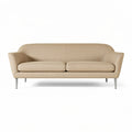 Moderne beige bank met slanke metalen poten